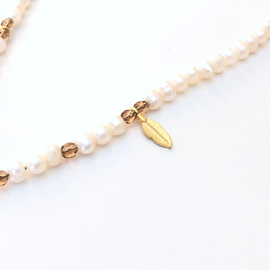 Elegante collar de perlas naturales con una espectacular libélula y hojas de Zamak con baño de oro mate. Además los toques de cristal facetado le aporta un toque de luz a la pieza que hacen que este collar sea perfecto para combinar con tu look favorito. Detalle cristal, hoja y perlas